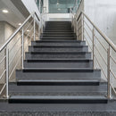 Black PVC hard nose stair nosings with midnight grey anti-slip inserts fitted to concrete steps in a commercial stairwell