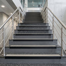 Black PVC hard nose stair nosings with canvas anti-slip inserts fitted to concrete steps in a commercial stairwell
