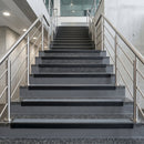 Black PVC hard nose stair nosings with midnight grey anti-slip inserts fitted to concrete steps in a commercial stairwell