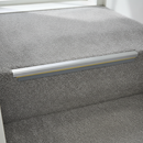 Dolphin grey anti-slip PVC stair nosing insert strip fitted into an aluminium stair nosing channel on a carpeted stair edge
