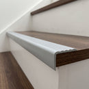 Silver flexible PVC stair nosing 40mm x 25mm fitted over the front edge of a dark walnut laminate stair tread