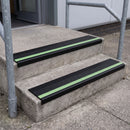 PVC stair nosing 60x32mm with black anti-slip insert fitted to external concrete steps, green photoluminescent strip along the front edge