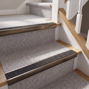 Rake back aluminium stair nosing with a dark charcoal Mor Grip insert in dark bronze finish fitted on a domestic staircase finished in light grey carpet