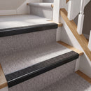 Rake back aluminium stair nosing with a dark charcoal Mor Grip insert in satin black finish fitted on a domestic staircase finished in light grey carpet