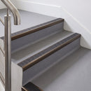 Rake back aluminium stair nosing with a dark charcoal Mor Grip insert in dark bronze finish fitted on an office stair finished in grey lino