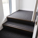 Rake back aluminium stair nosing with a dark charcoal Mor Grip insert in dark bronze finish fitted on an office stairwell finished in charcoal contract carpet