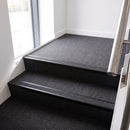 Rake back aluminium stair nosing with a dark charcoal Mor Grip insert in satin black finish fitted on an office stairwell finished in charcoal contract carpet