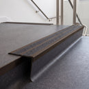Rake back aluminium stair nosing with twin dark charcoal Mor Grip inserts in dark bronze finish fitted on a college stair finished in dark grey sheet vinyl