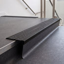 Rake back aluminium stair nosing with twin dark charcoal Mor Grip inserts in satin black finish fitted on a college stair finished in dark grey sheet vinyl