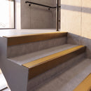 Dark Bronze rake back DDA aluminium stair nosing 70 x 56mm with Solar yellow High Grip insert, fitted on raked concrete stairs in a commercial stairwell