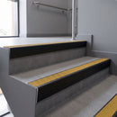 Aluminium rake back stair nosing 56 x 56mm, Brimstone Exterior Grip insert, Satin Black finish, fitted to concrete steps