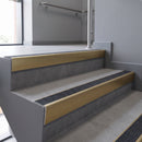 Aluminium rake back stair nosing 56 x 56mm, Obsidian Mor Grip insert, Satin Gold finish, fitted to concrete steps