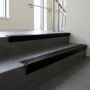 Black Anodised raked back aluminium stair nosing 62x55mm with Black Castellated infill, fitted to a concrete step