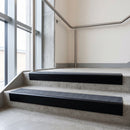 Black Anodised raked back aluminium stair nosing 62x55mm with Black Olympic Grip infill, fitted to a concrete step