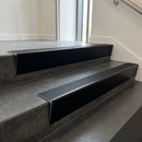 Black Anodised raked back aluminium stair nosing 62x55mm with Black Smooth Textured infill, fitted to a concrete step