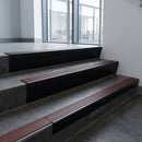 Black Anodised raked back aluminium stair nosing 62x55mm with Claret Castellated infill, fitted to a concrete step