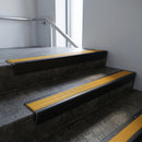 Black Anodised raked back aluminium stair nosing 62x55mm with Gold Castellated infill, fitted to a concrete step