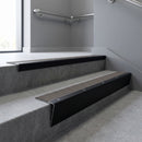 Black Anodised raked back aluminium stair nosing 62x55mm with Granite Castellated infill, fitted to a concrete step