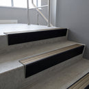 Black Anodised raked back aluminium stair nosing 62x55mm with Light Bronze Aluminium infill, fitted to a concrete step