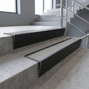 Black Anodised raked back aluminium stair nosing 62x55mm with Light Grey Castellated infill, fitted to a concrete step