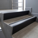 Black Anodised raked back aluminium stair nosing 62x55mm with Light Grey Smooth Textured infill, fitted to a concrete step