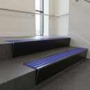 Black Anodised raked back aluminium stair nosing 62x55mm with Mid Blue Castellated infill, fitted to a concrete step