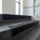 Black Anodised raked back aluminium stair nosing 62x55mm with Peat Castellated infill, fitted to a concrete step