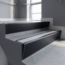 Black Anodised raked back aluminium stair nosing 62x55mm with Polar Grey Smooth Textured infill, fitted to a concrete step