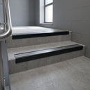 Black Anodised raked back aluminium stair nosing 62x55mm with Polished Aluminium infill, fitted to a concrete step