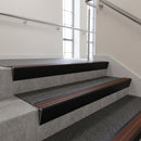 Black Anodised raked back aluminium stair nosing 62x55mm with Rustic Castellated infill, fitted to a concrete step