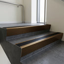 Bronze raked back aluminium stair nosing 62x55mm with Black Smooth Textured infill, fitted to a concrete step