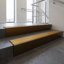 Bronze raked back aluminium stair nosing 62x55mm with Gold Castellated infill, fitted to a concrete step