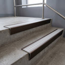 Bronze raked back aluminium stair nosing 62x55mm with Polar Grey Castellated infill, fitted to a concrete step