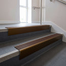 Bronze raked back aluminium stair nosing 62x55mm with Rustic Castellated infill, fitted to a concrete step