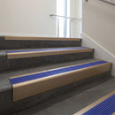 Light Bronze raked back aluminium stair nosing 62x55mm with Mid Blue Castellated infill, fitted to a concrete step