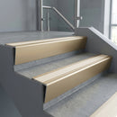 Light Bronze raked back aluminium stair nosing 62x55mm with Porth Stone Castellated infill, fitted to a concrete step