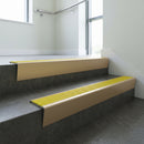 Light Bronze raked back aluminium stair nosing 62x55mm with Yellow Castellated infill, fitted to a concrete step