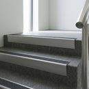 Mill Aluminium raked back aluminium stair nosing 62x55mm with Black Olympic Grip infill, fitted to a concrete step