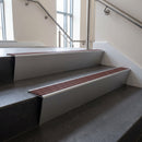 Mill Aluminium raked back aluminium stair nosing 62x55mm with Claret Castellated infill, fitted to a concrete step