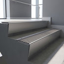 Mill Aluminium raked back aluminium stair nosing 62x55mm with Flint Castellated infill, fitted to a concrete step
