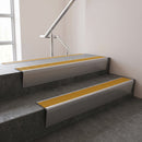 Mill Aluminium raked back aluminium stair nosing 62x55mm with Gold Castellated infill, fitted to a concrete step