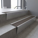 Mill Aluminium raked back aluminium stair nosing 62x55mm with Granite Castellated infill, fitted to a concrete step