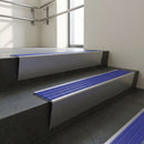 Mill Aluminium raked back aluminium stair nosing 62x55mm with Mid Blue Castellated infill, fitted to a concrete step