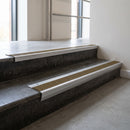 Mill Aluminium raked back aluminium stair nosing 62x55mm with Olive Castellated infill, fitted to a concrete step