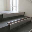 Mill Aluminium raked back aluminium stair nosing 62x55mm with Peat Castellated infill, fitted to a concrete step