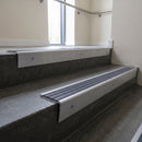 Mill Aluminium raked back aluminium stair nosing 62x55mm with Regency Castellated infill, fitted to a concrete step