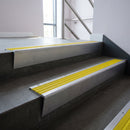 Mill Aluminium raked back aluminium stair nosing 62x55mm with Yellow Castellated infill, fitted to a concrete step
