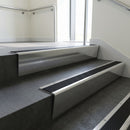 Polished Aluminium raked back aluminium stair nosing 62x55mm with Black Castellated infill, fitted to a concrete step