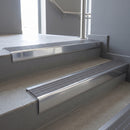 Polished Aluminium raked back aluminium stair nosing 62x55mm with Flint Castellated infill, fitted to a concrete step