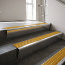 Polished Aluminium raked back aluminium stair nosing 62x55mm with Gold Castellated infill, fitted to a concrete step